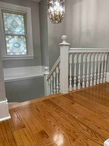 a view of a bedroom with wooden floor and windows