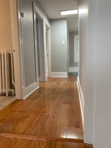 a view of a livingroom with wooden floor and a staircase