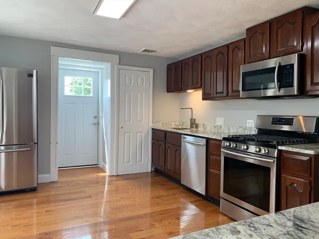a kitchen with stainless steel appliances granite countertop a stove microwave and refrigerator