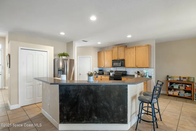 a kitchen with refrigerator and cabinets