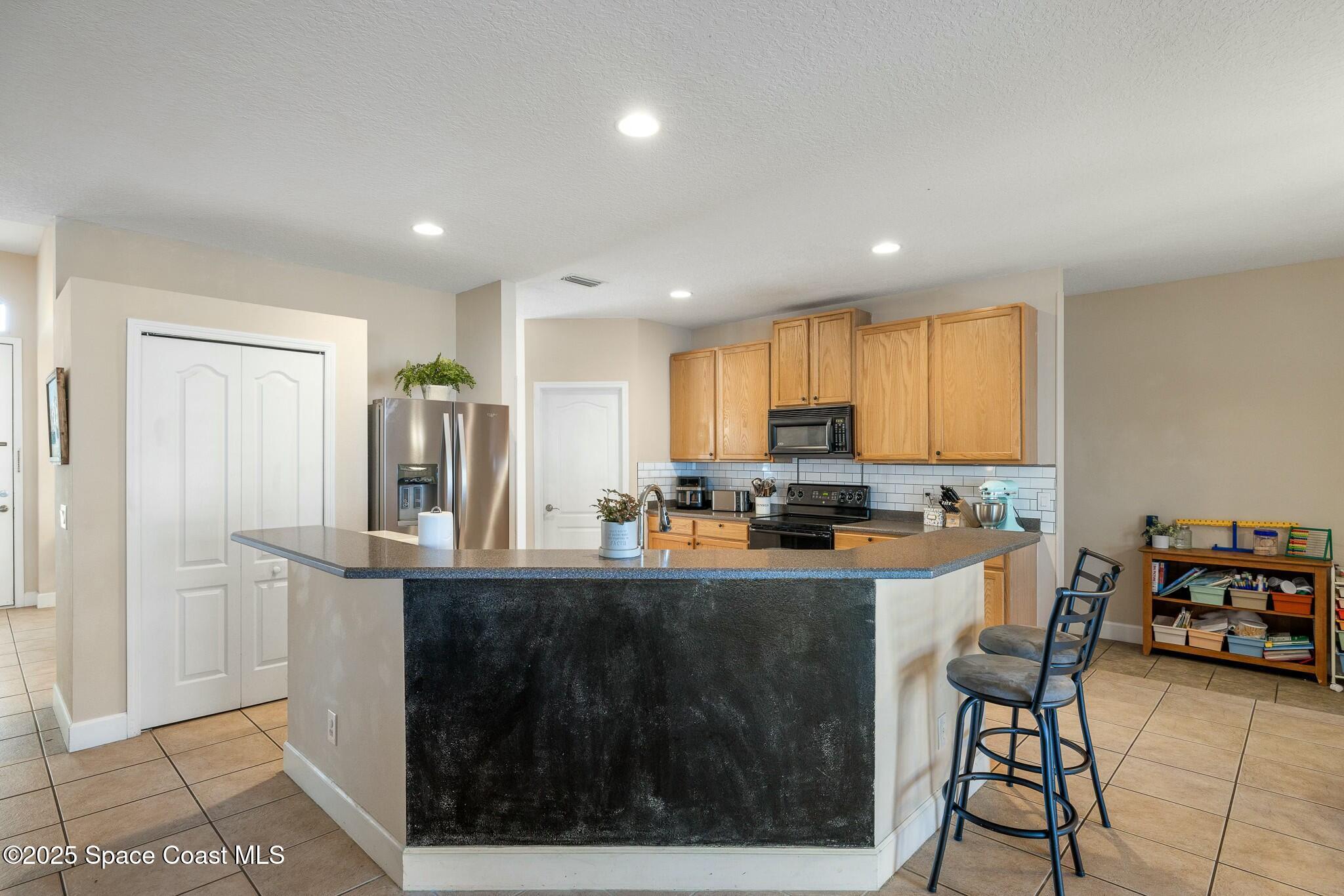 320 Pebble Hill Way Rockledge, FL 32955 - Photo 13 of 34 a kitchen with refrigerator and cabinets