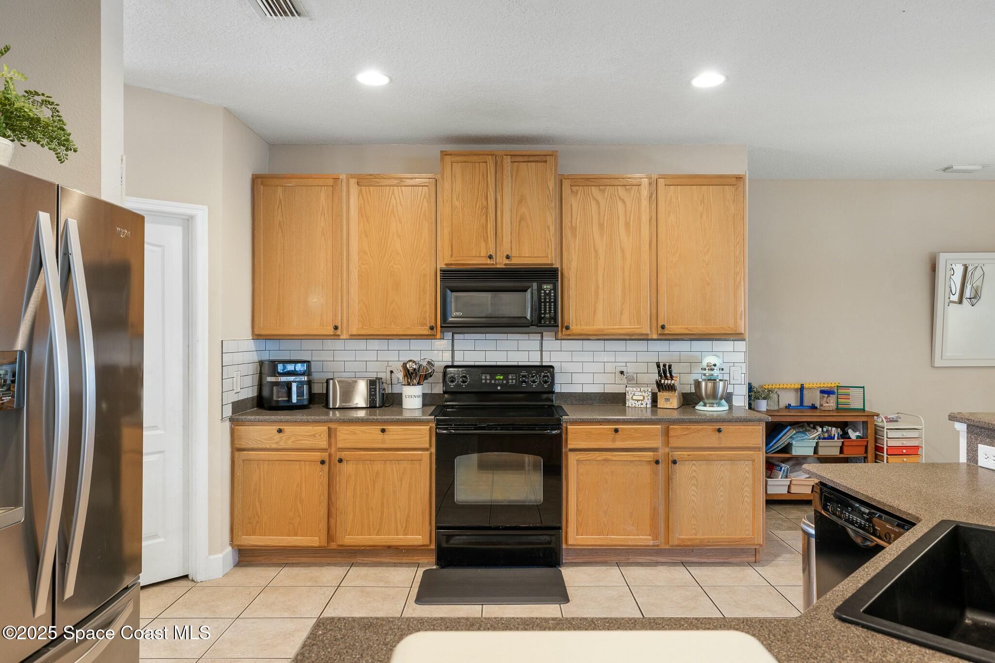 320 Pebble Hill Way Rockledge, FL 32955 - Photo 14 of 34 a kitchen with a stove a sink and a refrigerator