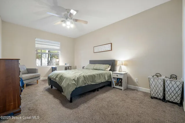 a spacious bedroom with a bed and a chandelier