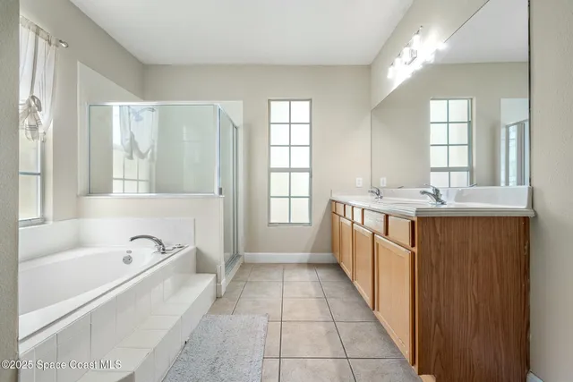 a large spacious bathroom with a tub sink and mirror