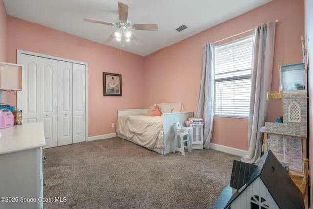 a spacious bedroom with a bed and a chandelier