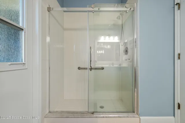 a bathroom with a glass shower door