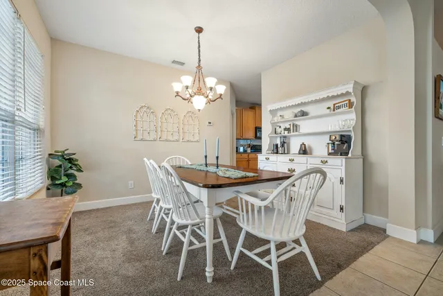 a view of a dining room with furniture and chandelier