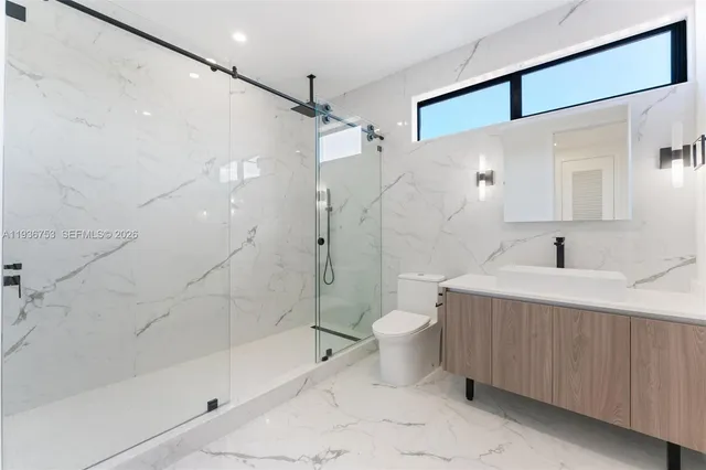 a bathroom with a bathtub shower sink mirror and toilet