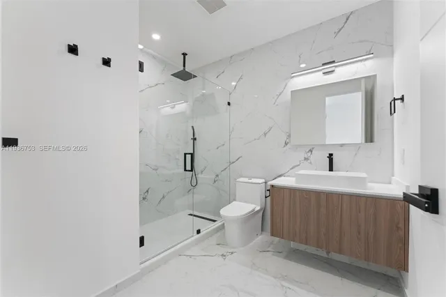 a spacious bathroom with a bathtub shower sink mirror and toilet