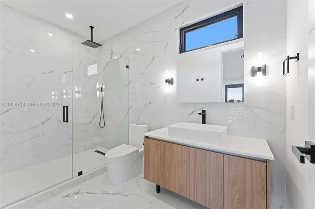 a bathroom with a sink a toilet and shower