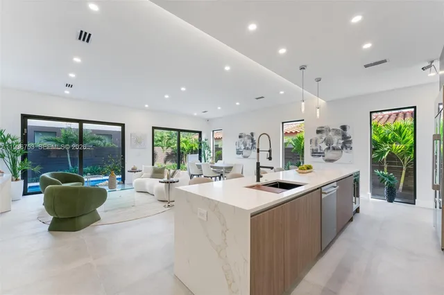 a large kitchen with kitchen island a large window in it