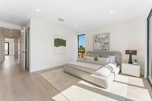 a bedroom with a large bed and a painting on the wall