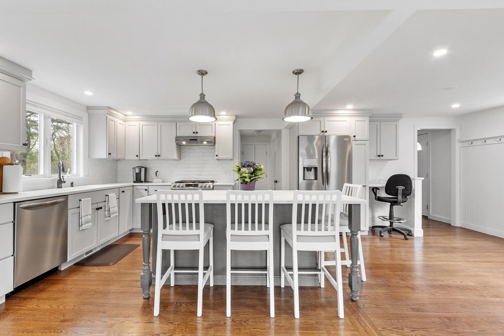 122 Southfield Road Concord, MA 01742 - Photo 2 of 28 a kitchen with stainless steel appliances granite countertop a dining table chairs stove and white cabinets