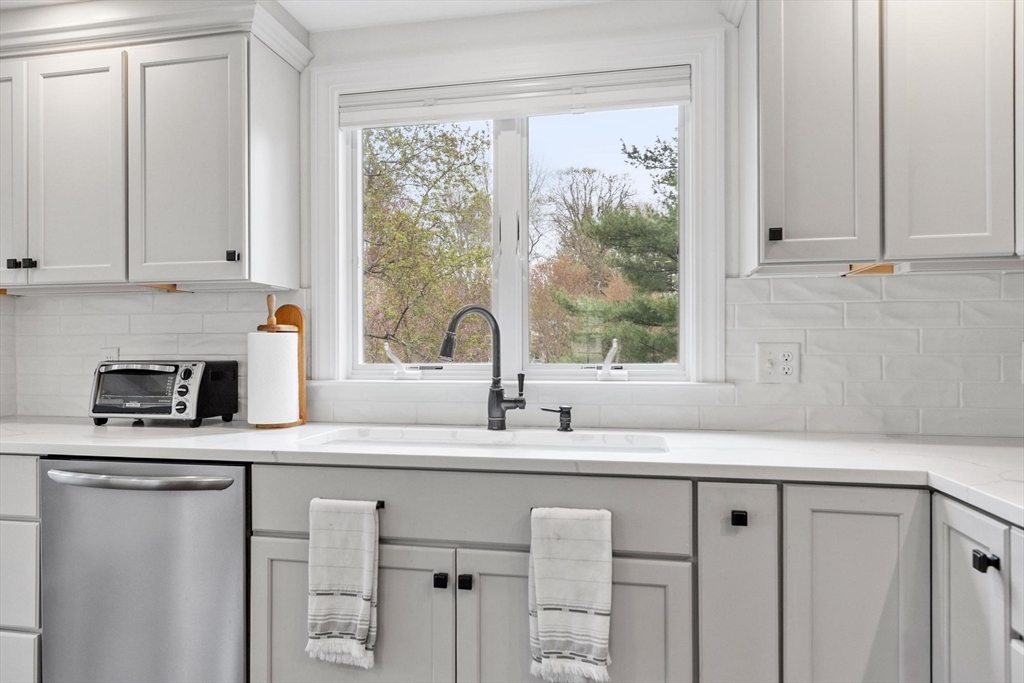 122 Southfield Road Concord, MA 01742 - Photo 4 of 28 a kitchen with granite countertop a sink white cabinets and a window