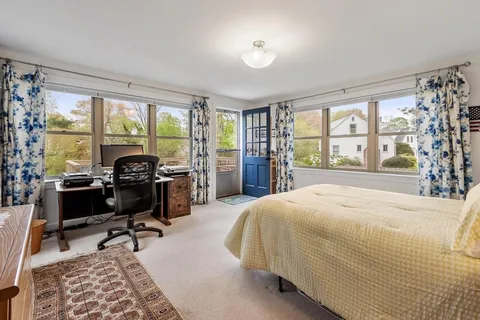 a bedroom with a bed and a large window