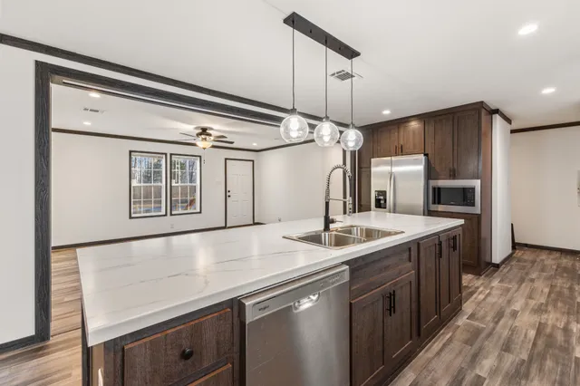a kitchen with stainless steel appliances granite countertop a sink and a refrigerator