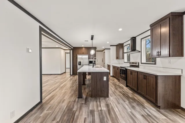 a kitchen with stainless steel appliances granite countertop a sink stove and wooden floor
