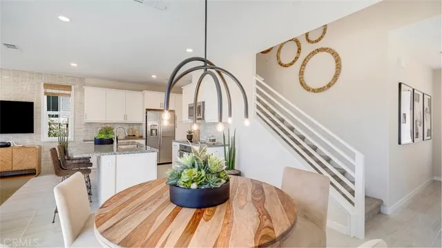 a dining room with furniture a potted plant and a chandelier