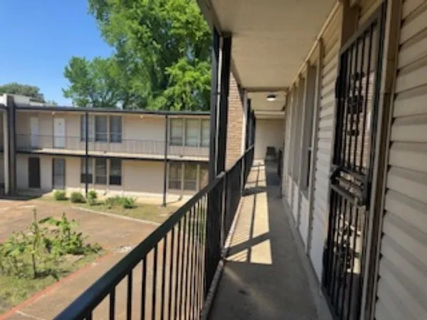 a view of a balcony with wooden floor and fence