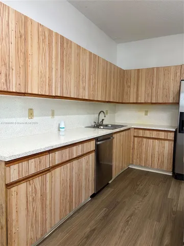 a kitchen with wooden cabinets and sink