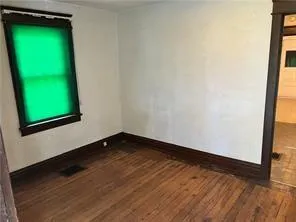 a view of a room with wooden floor and a window