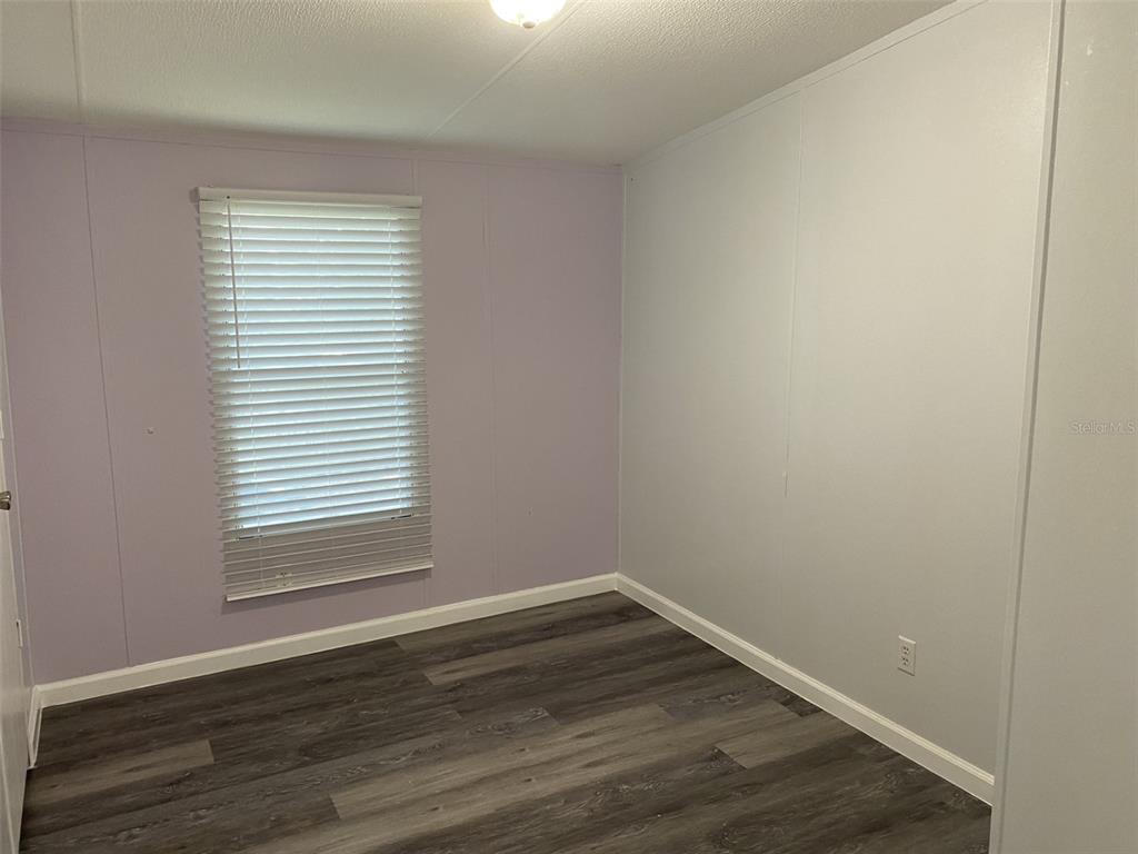 1604 Vintage Street Kissimmee, FL 34746 - Photo 12 of 23 a view of an empty room with wooden floor and a window