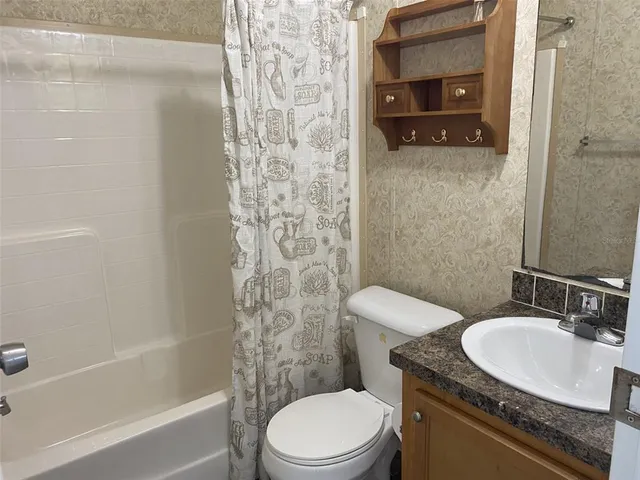 a bathroom with a granite countertop toilet sink and shower