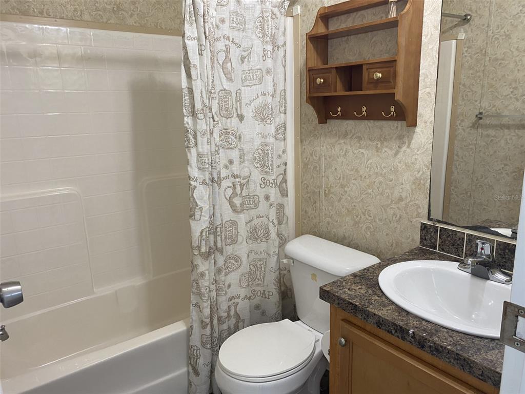 1604 Vintage Street Kissimmee, FL 34746 - Photo 13 of 23 a bathroom with a granite countertop toilet sink and shower