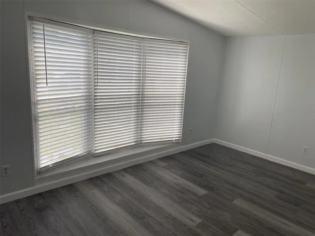 an empty room with wooden floor and a window