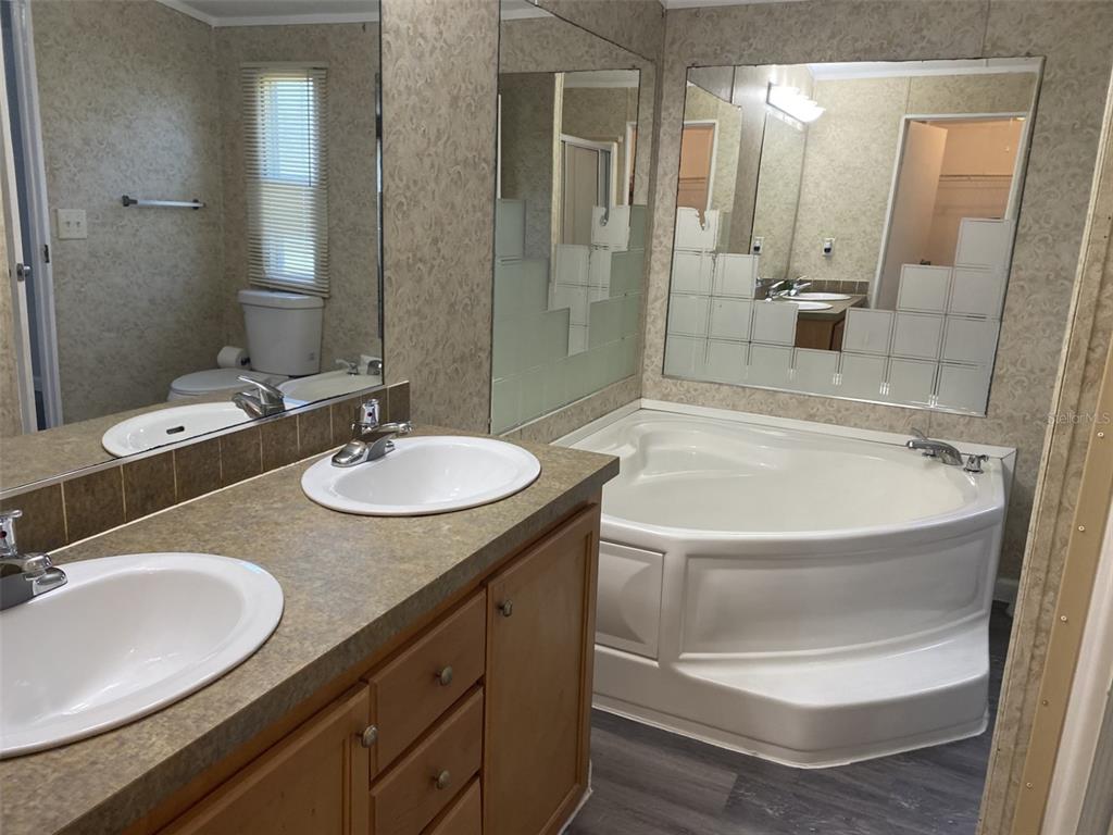 1604 Vintage Street Kissimmee, FL 34746 - Photo 16 of 23 a bathroom with a sink double vanity granite tub shower and a mirror