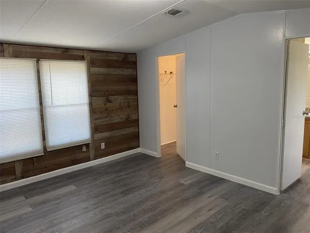 an empty room with wooden floor and closet