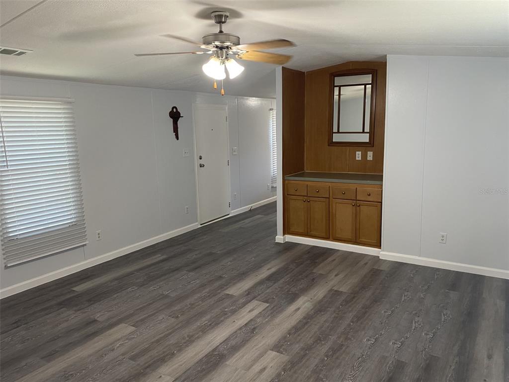 1604 Vintage Street Kissimmee, FL 34746 - Photo 5 of 23 an empty room with wooden floor chandelier fan and windows