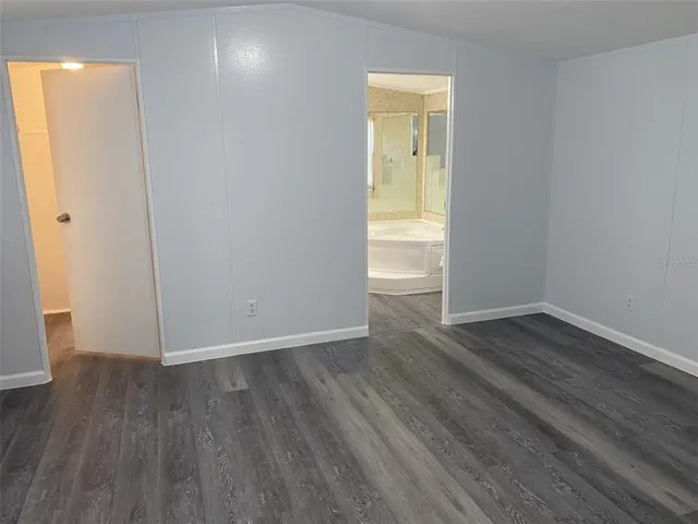 an empty room with wooden floor and closet