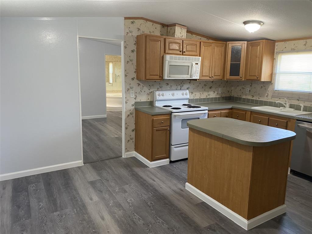 1604 Vintage Street Kissimmee, FL 34746 - Photo 9 of 23 a kitchen with stainless steel appliances granite countertop a stove a sink and a microwave