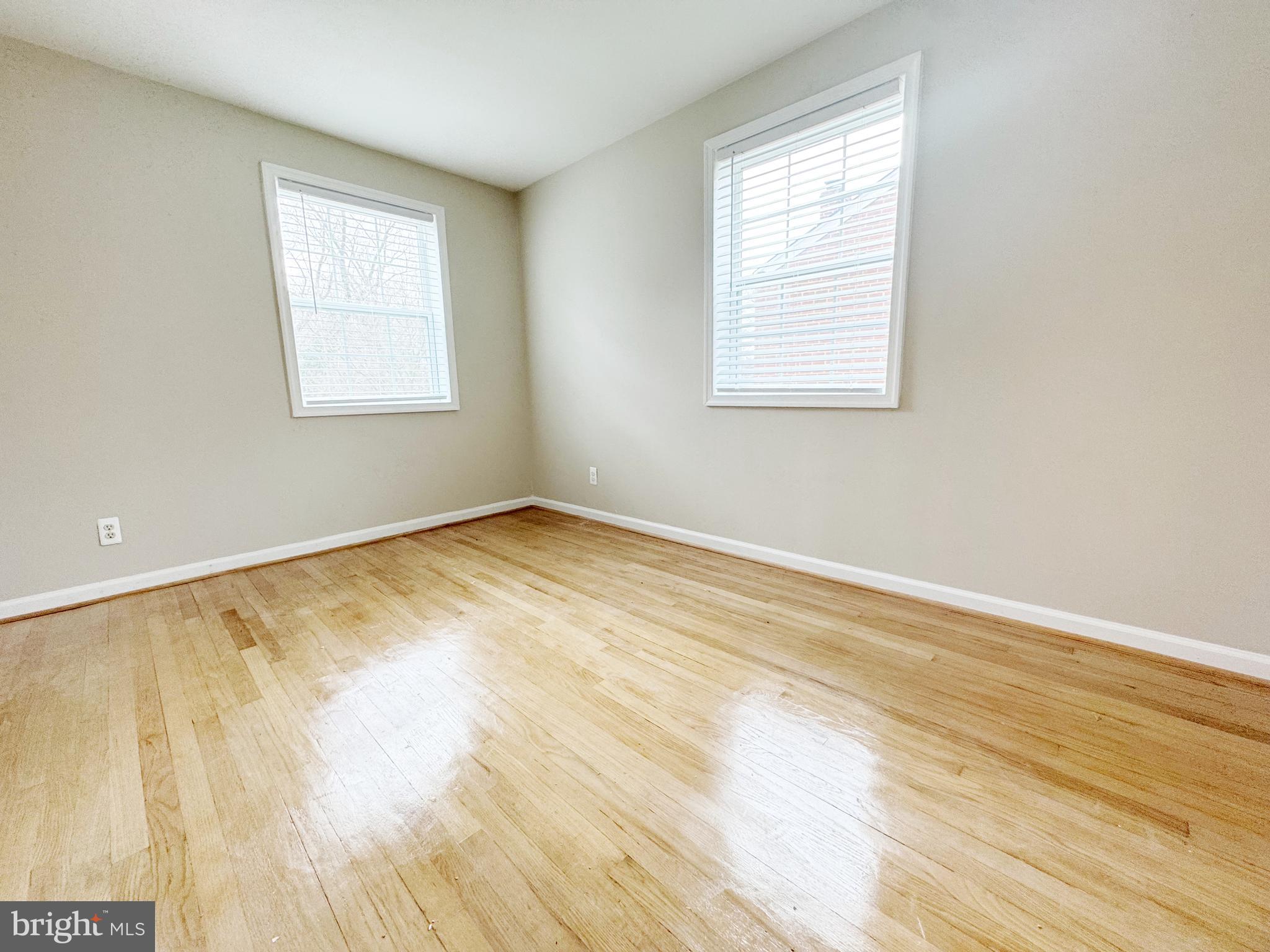 11969 Andrew Street Silver Spring, MD 20902 - Photo 12 of 20 a view of an empty room with wooden floor and a window