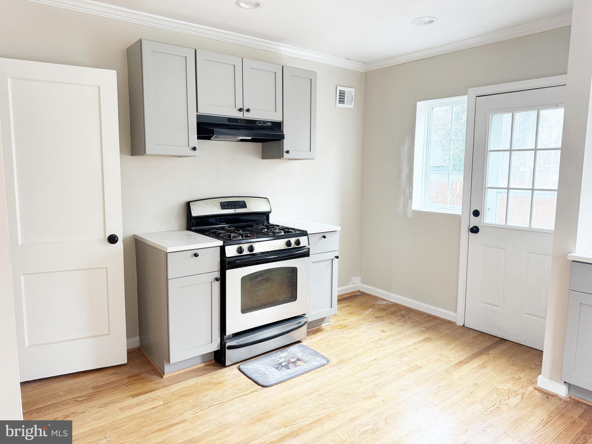 11969 Andrew Street Silver Spring, MD 20902 - Photo 4 of 20 a kitchen with stainless steel appliances white cabinets and a stove top oven