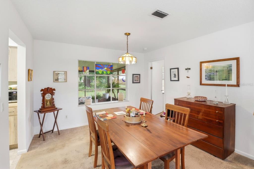 3103 South Bay Berry Point Inverness, FL 34450 - Photo 19 of 50 a dining room with wooden floor a chandelier a wooden table and chairs