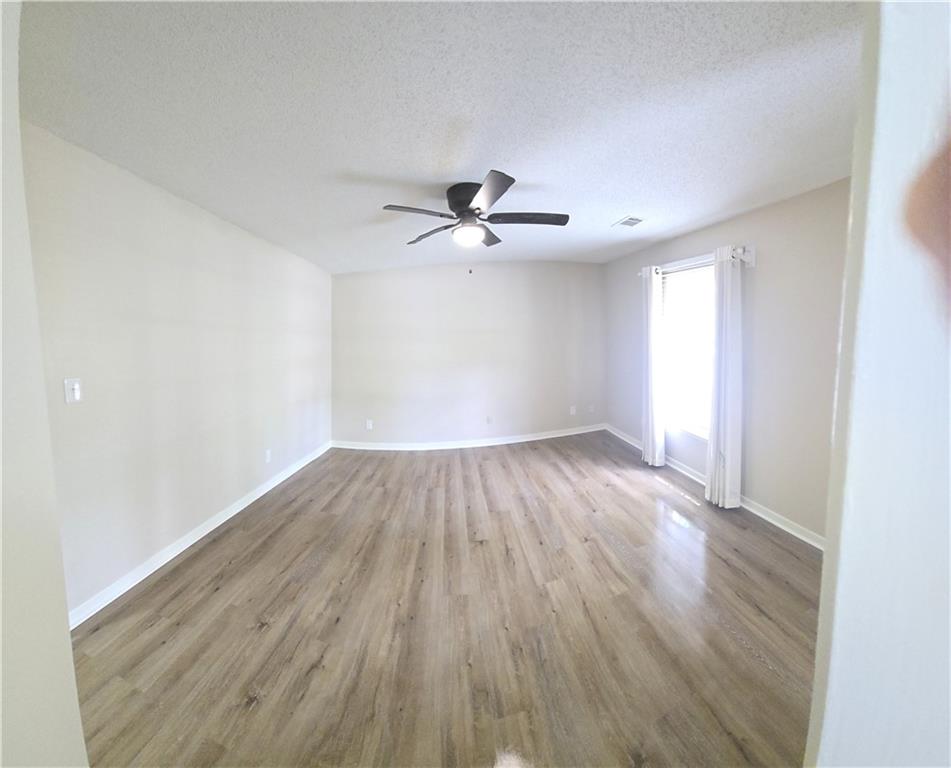 11013 Clearwater Drive Hampton, GA 30228 - Photo 17 of 23 an empty room with wooden floor and ceiling fan