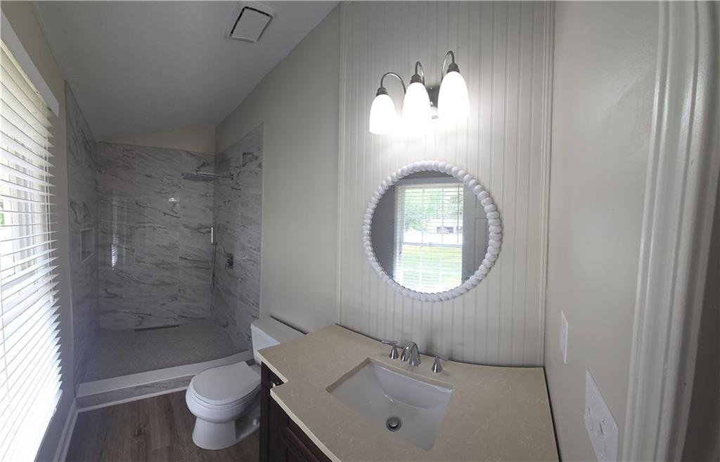 11013 Clearwater Drive Hampton, GA 30228 - Photo 18 of 23 a bathroom with a toilet sink a mirror and a window