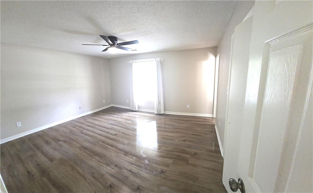 11013 Clearwater Drive Hampton, GA 30228 - Photo 21 of 23 an empty room with wooden floor fan and windows