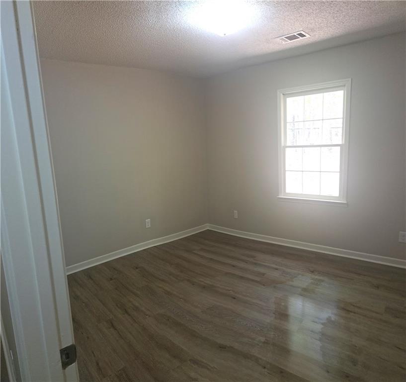 11013 Clearwater Drive Hampton, GA 30228 - Photo 23 of 23 an empty room with wooden floor and windows