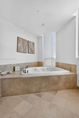 a view of a dining room with furniture a chandelier and a large window
