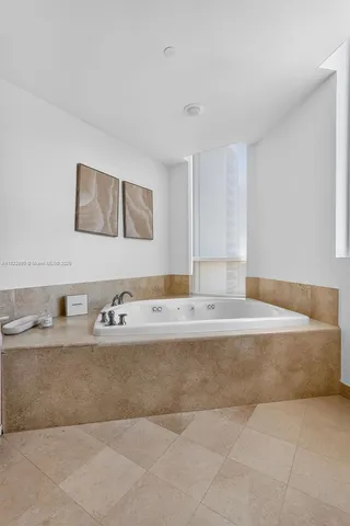 a view of a dining room with furniture a chandelier and a large window