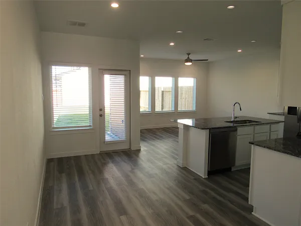 a kitchen with a sink and wooden floor