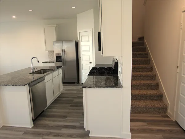 a kitchen with a sink a refrigerator and cabinets