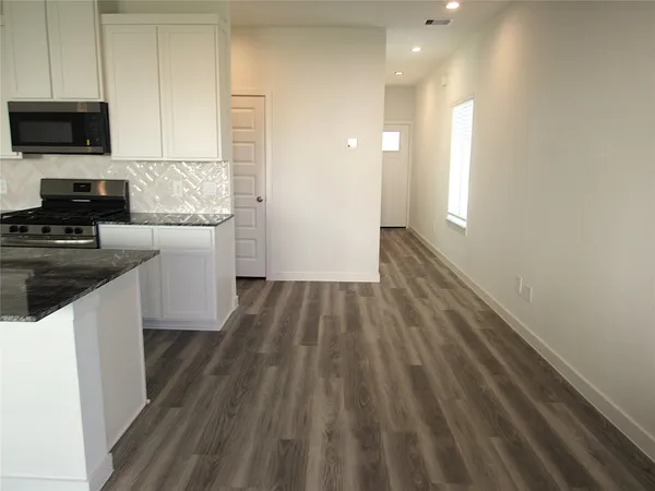 a kitchen with a refrigerator and a stove top oven