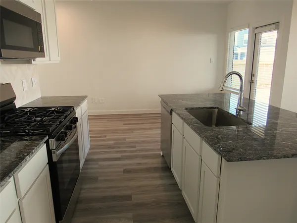 a kitchen with sink microwave and stove