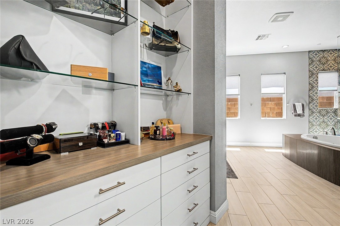 6014 Willow Ridge Court Las Vegas, NV 89135 - Photo 45 of 99 This spacious walk-in closet seamlessly transitions into a bright, contemporary bathroom space.