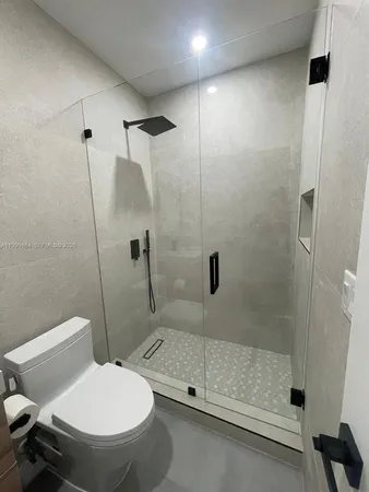 a bathroom with a toilet and a shower