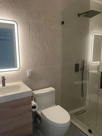a white toilet sitting next to a bathroom sink